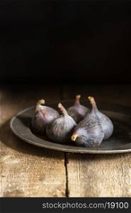 Fresh figs in moody natural lighting set with vintage style