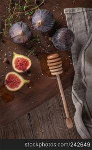 Fresh figs. Whole figs and sliced in half figs and thyme leaves on wooden cutting board. Flat layer.