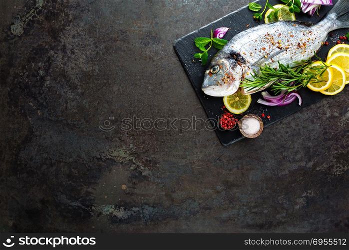 Fresh fish dorado. Raw dorado fish and ingredient for cooking on board. Sea bream or dorada fish on kitchen table