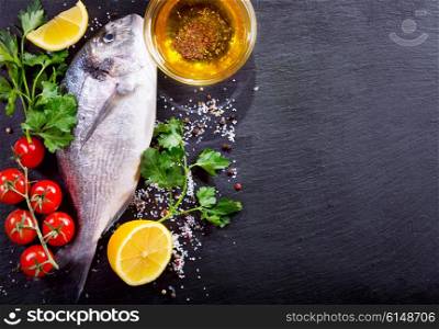 fresh fish dorado with vegetables on dark background