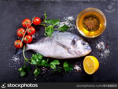 fresh fish dorado with vegetables on dark background