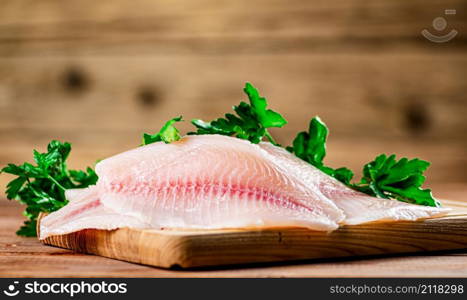 Fresh fish fillet on a cutting board. On a wooden background. High quality photo. Fresh fish fillet on a cutting board.