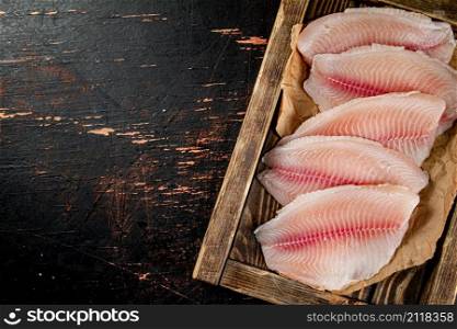 Fresh fish fillet on the tray. On a rustic dark background. High quality photo. Fresh fish fillet on the tray.