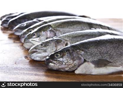 Fresh fish heads in a row on dark walnut board