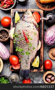 Fresh fish with ingredients for cooking on cutting board.Cooking concept.Healthy diet. Fresh raw fish and food ingredients