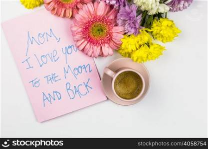 fresh flowers near paper with words cup drink