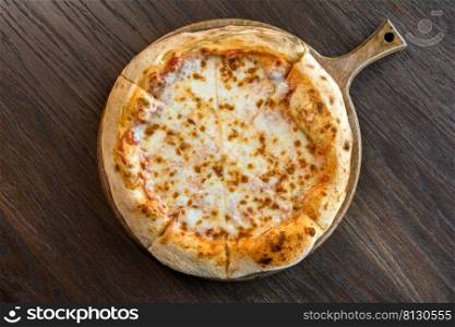 Fresh four cheese pizza sliced on wooden table