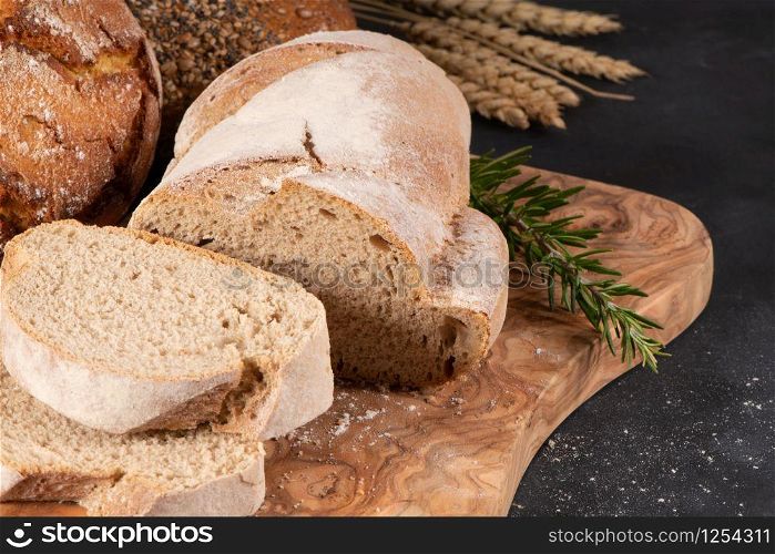 Fresh fragrant bread on the table. Food concept. Bakery, crusty loaves of bread and buns. Assortment of baked bread.