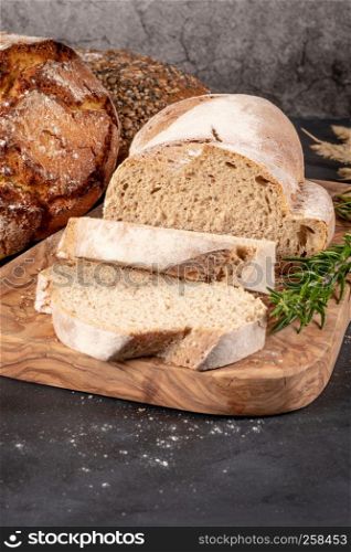 Fresh fragrant bread on the table. Food concept. Bakery, crusty loaves of bread and buns. Assortment of baked bread.