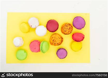 Fresh fresh macaroon sweets over yellow background, top view. Fresh macaroon confection
