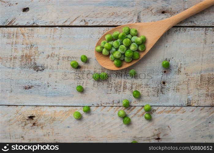 Fresh frozen peas on a spoon. Vegetable food background healthy vegetarian natural meal.