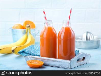 fresh fruit juice in bottle and on a table