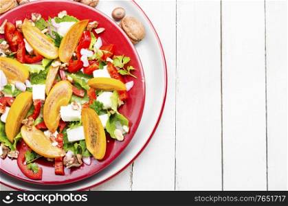 Fresh fruit salad with persimmons and cheese.Copy space. Salad with persimmon