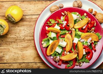 Fresh fruit salad with persimmons and cheese. Salad with persimmon