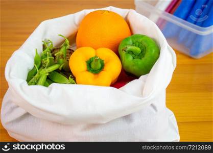 Fresh fruits and vegetables organic in eco cotton fabric bags on wooden table, not used plastic bag. Concept save the earth.