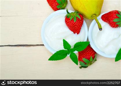 fresh fruits and whole milk yogurt on a rustic wood table