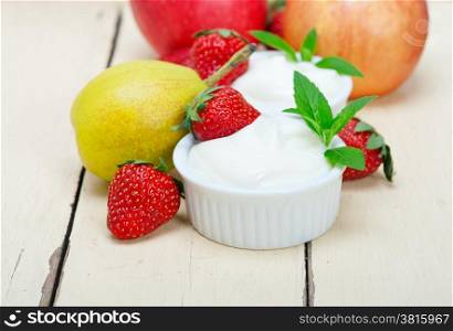 fresh fruits and whole milk yogurt on a rustic wood table