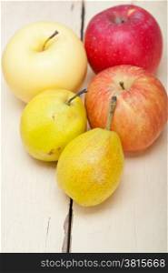 fresh fruits apples and pears on a white wood table