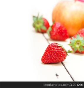 fresh fruits apples pears and strawberry on a white wood table