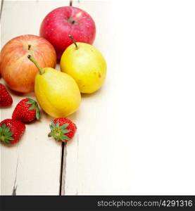 fresh fruits apples pears and strawberry on a white wood table