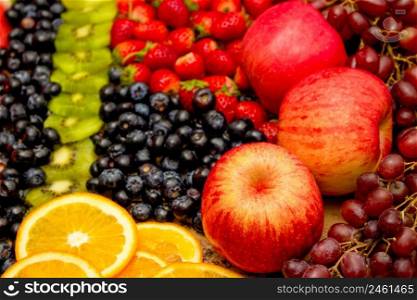 Fresh fruits concept, Arrangement of kiwi orange apple and assorted burry as background.