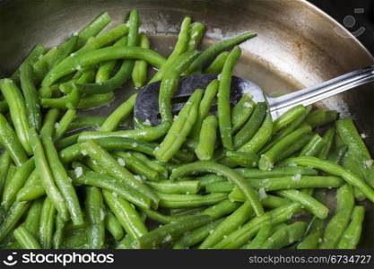 Fresh garden green beans and spatula in frying pan