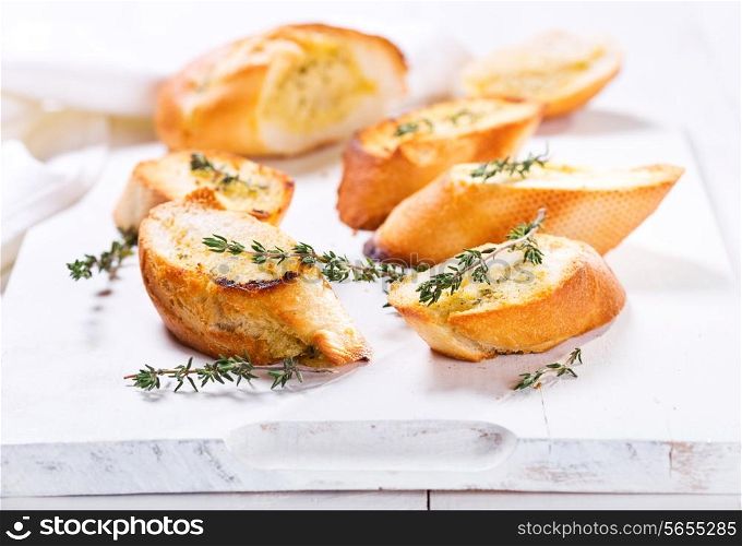 fresh garlic bread with herbs on wooden board