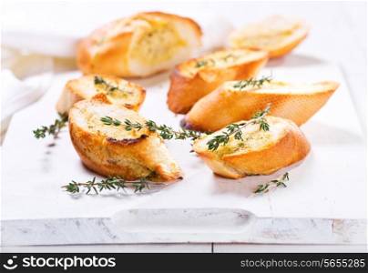 fresh garlic bread with herbs on wooden board