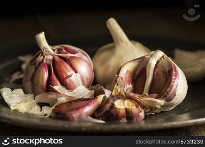 Fresh garlic cloves in moody natural lighting set up with vintage style. food, fresh, raw, fruit, vegetables, wood, wooden, background, grunge, retro, vintage, moody, dark,