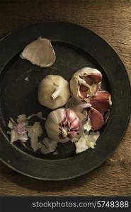 Fresh garlic cloves in moody natural lighting set up with vintage style