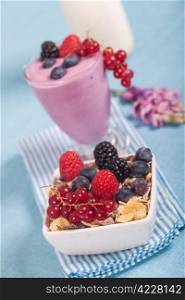 Fresh glass of delicious yogurt with berries and muesli