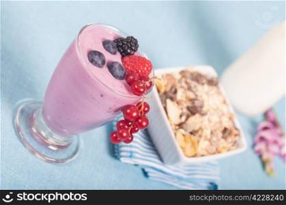 Fresh glass of delicious yogurt with berries and muesli