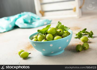 Fresh gooseberries in blue bowl. Top view.