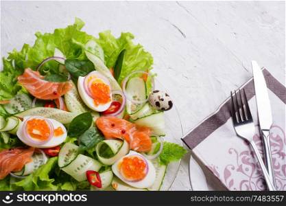 fresh gourmet salad with red salmon caviar and eggs and vegetables. Protein luxury delicacy healthy food. beautifull served at white table.