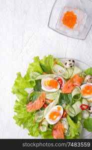 fresh gourmet salad with red salmon caviar and eggs and vegetables. Protein luxury delicacy healthy food. beautifull served at white table.