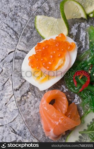 fresh gourmet salad with salmon, caviar, eggs and vegetables. Protein luxury delicacy healthy food. beautifull served around grey background.