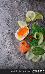 fresh gourmet salad with salmon, caviar, eggs and vegetables. Protein luxury delicacy healthy food. beautifull served around grey background.