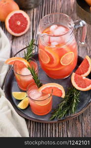 Fresh grapefruit cocktail. Fresh summer cocktail with grapefruit, lime, sprig of rosemary and ice cubes.