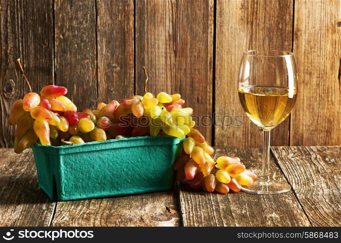 Fresh grapes and white wine on old wooden table
