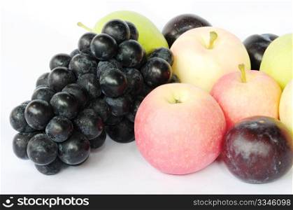 Fresh grapes, apples, pears and plums on a white background