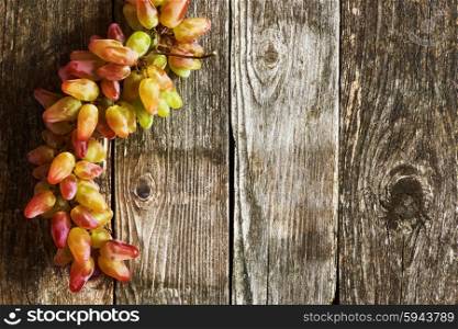 Fresh grapes on old wooden background