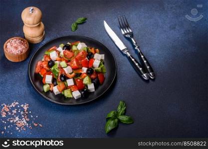Fresh greek salad with tomato, cucumber, bel pepper , olives and feta cheese on black plate. Greek salad with fresh vegetables, feta cheese and black olives