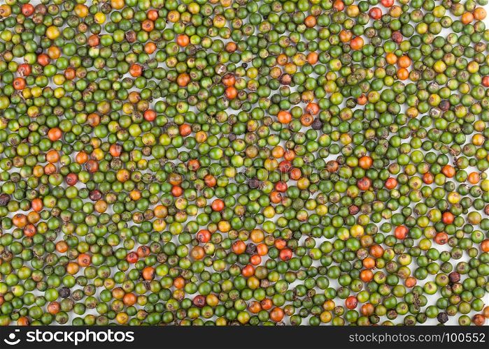 fresh green and orange peppercorns in background