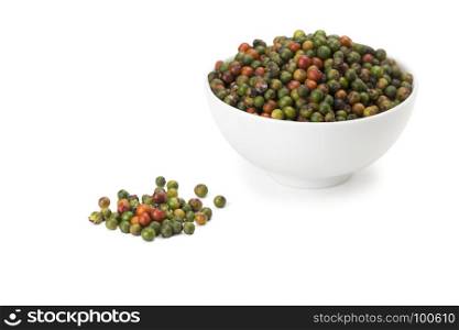 fresh green and orange peppercorns in white ceramic bowl on white background