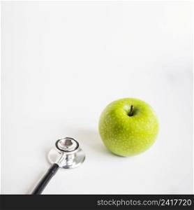 fresh green apple stethoscope white background