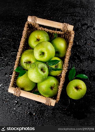 Fresh green apples in a basket. On a black background. High quality photo. Fresh green apples in a basket.