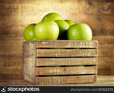 fresh green apples in wooden box