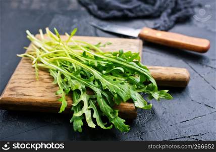 Fresh green arugula on wooden board. Arugula rucola for salad.