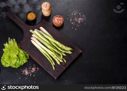 Fresh green asparagus on black slate background. Top view copy space. Bunch of fresh ripe green asparagus organic vegetables ready to cook or grill