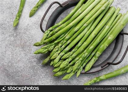 Fresh green asparagus on grey concrete background. Flat lay